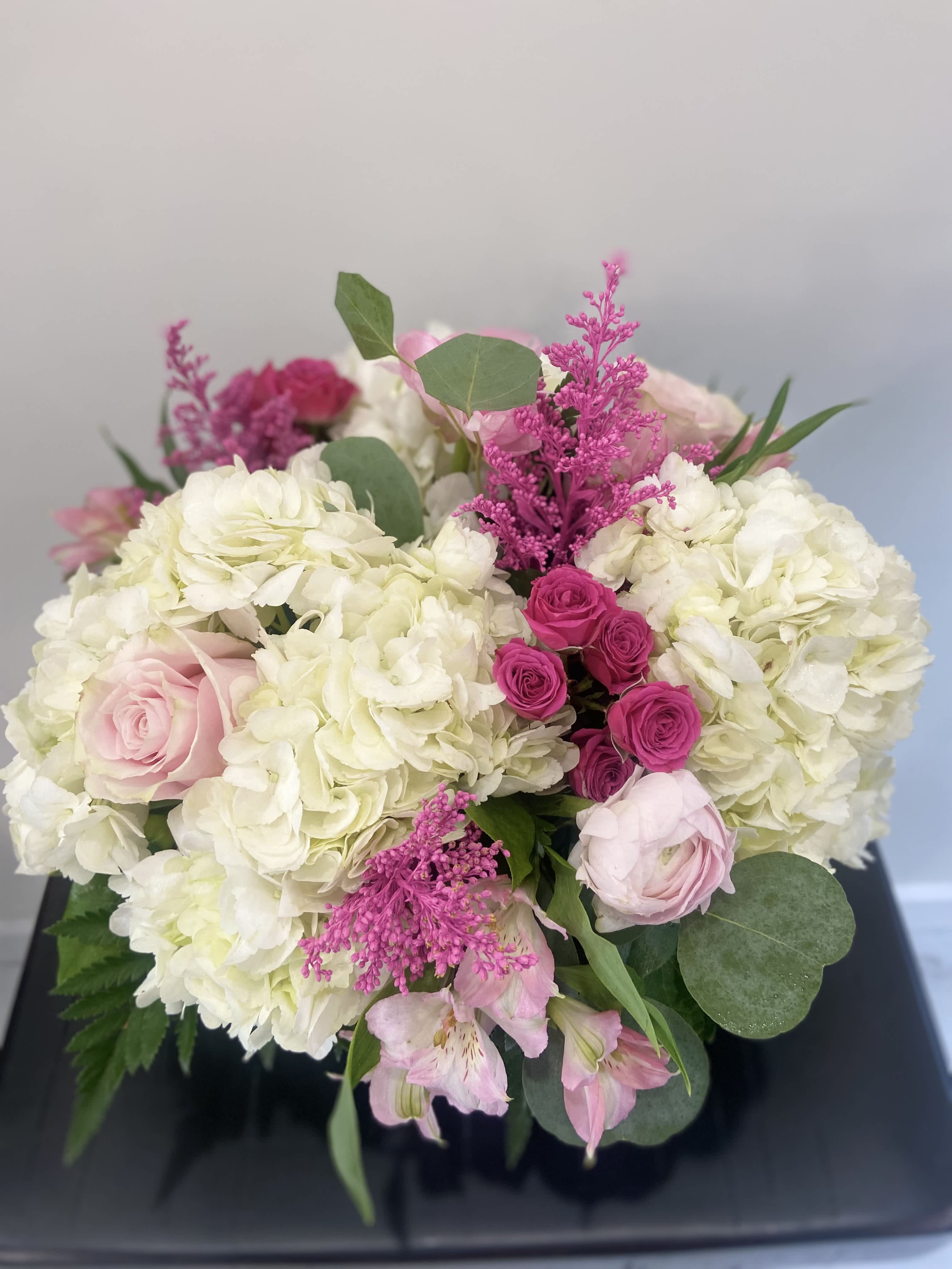 Bouquet of white hydrangeas, pink roses, and magenta filler flowers