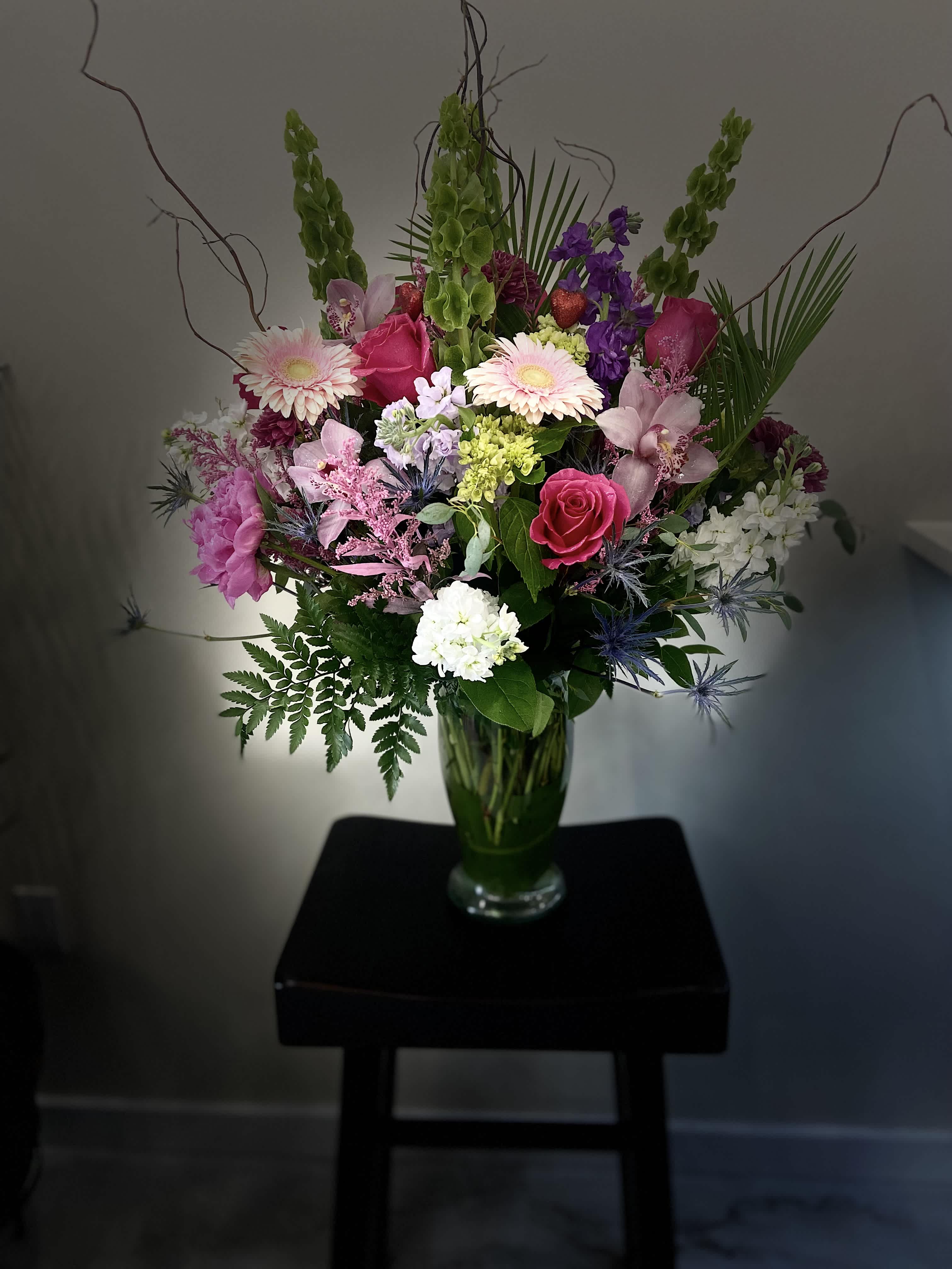 Mixed bouquet in a glass vase with pink, purple, and white flowers