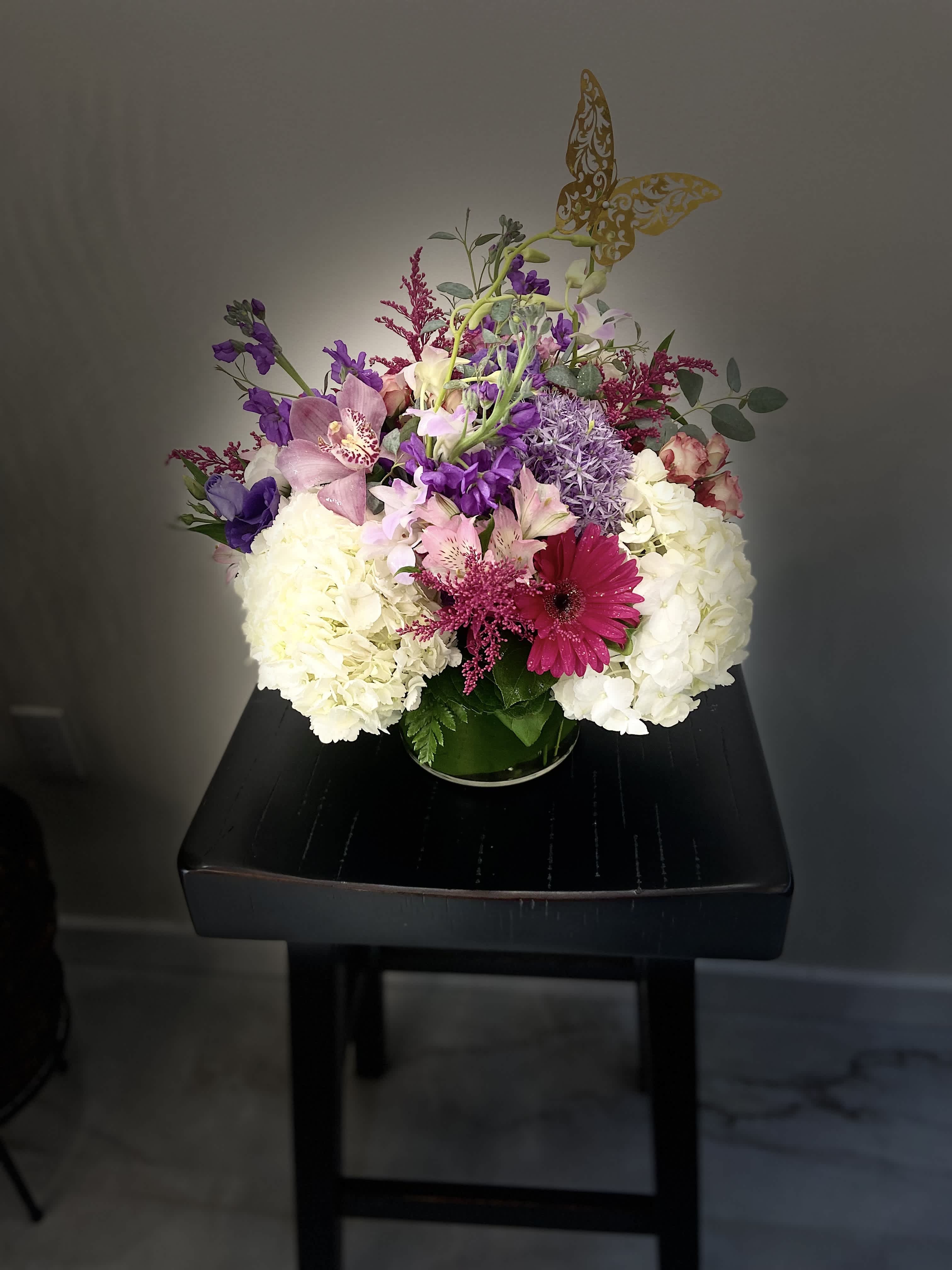 Mixed bouquet of white, pink, and purple flowers in a glass vase