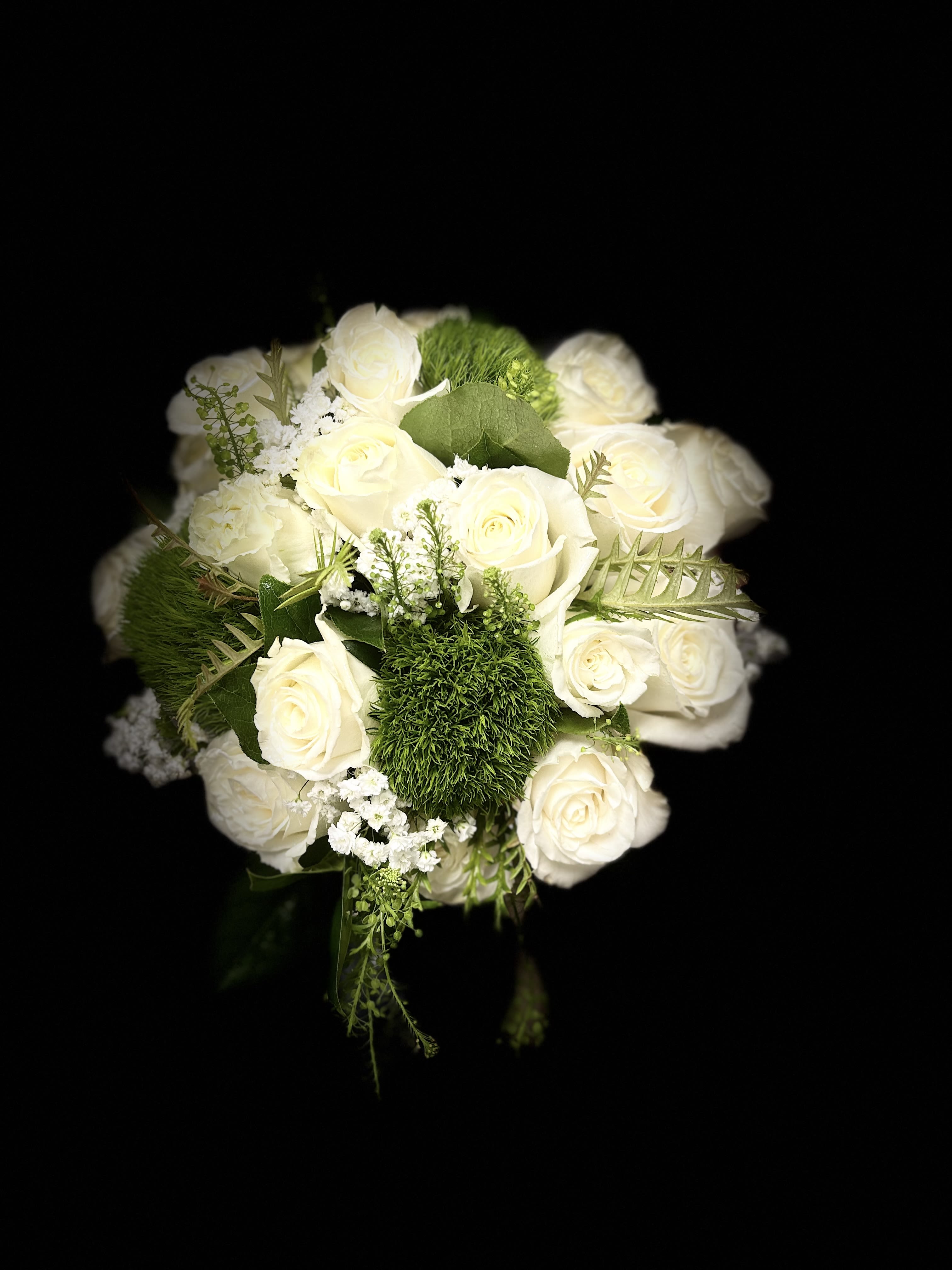 White rose bouquet with green accents on a black background