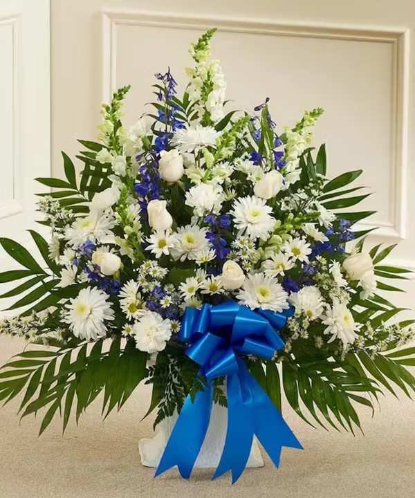 White and blue floral standing arrangement with a blue ribbon