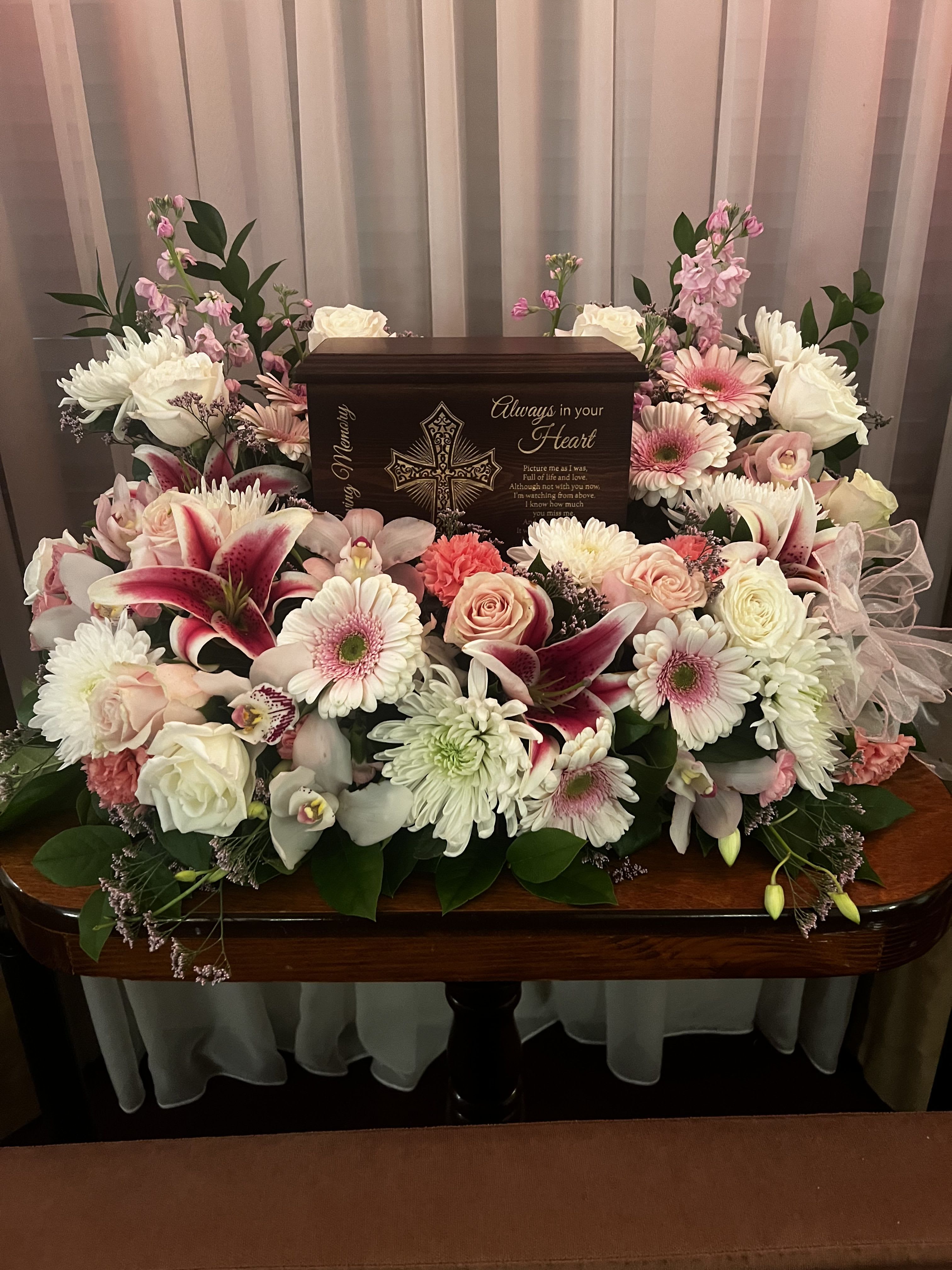 Sympathy floral arrangement around a memorial urn with pink and white flowers