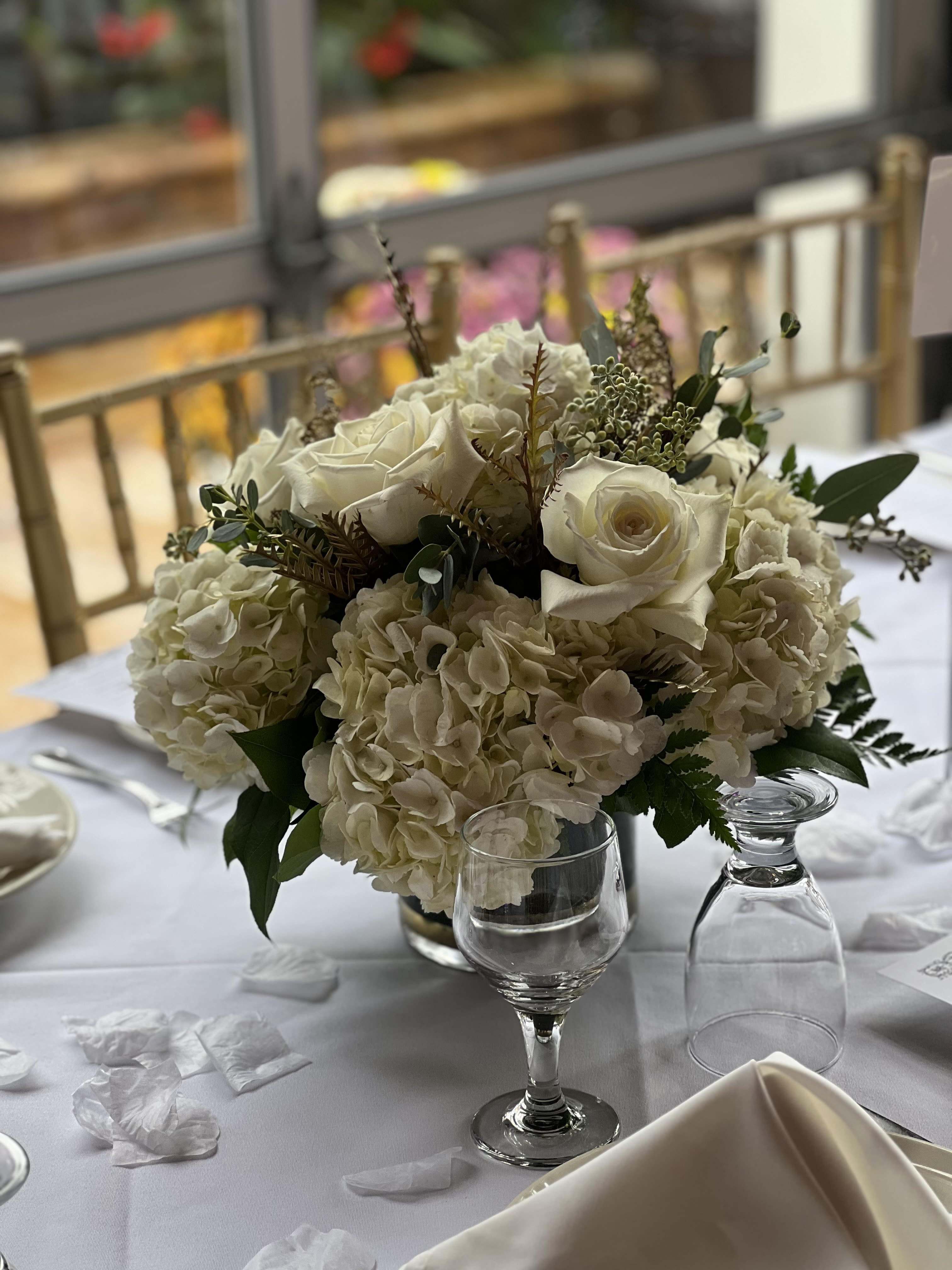 White rose and hydrangea centerpiece in a glass vase
