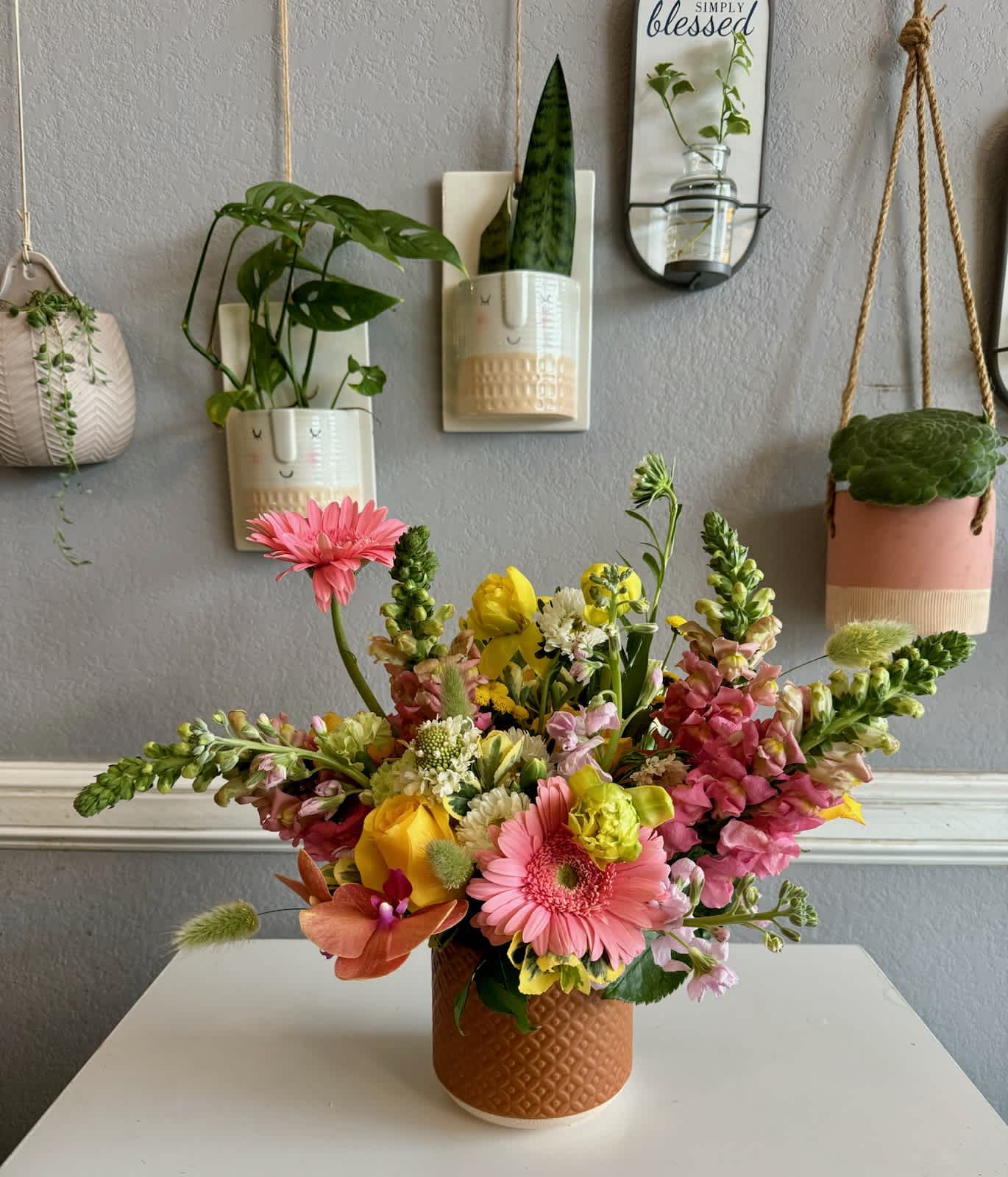 Colorful mixed flower arrangement in a textured brown vase