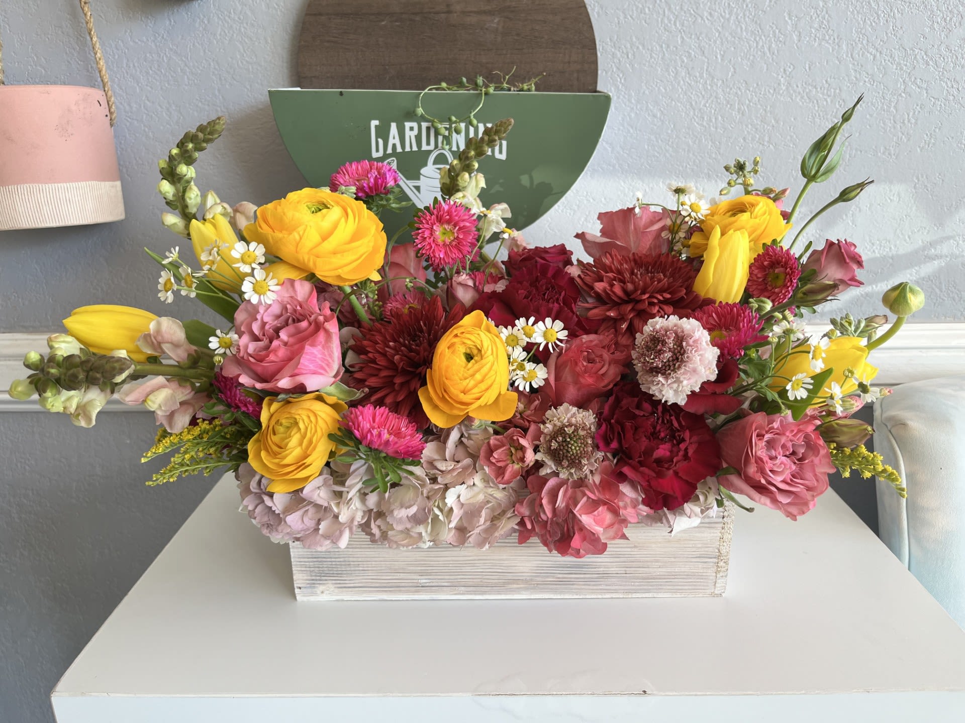 Colorful mixed flower arrangement in a white wooden box