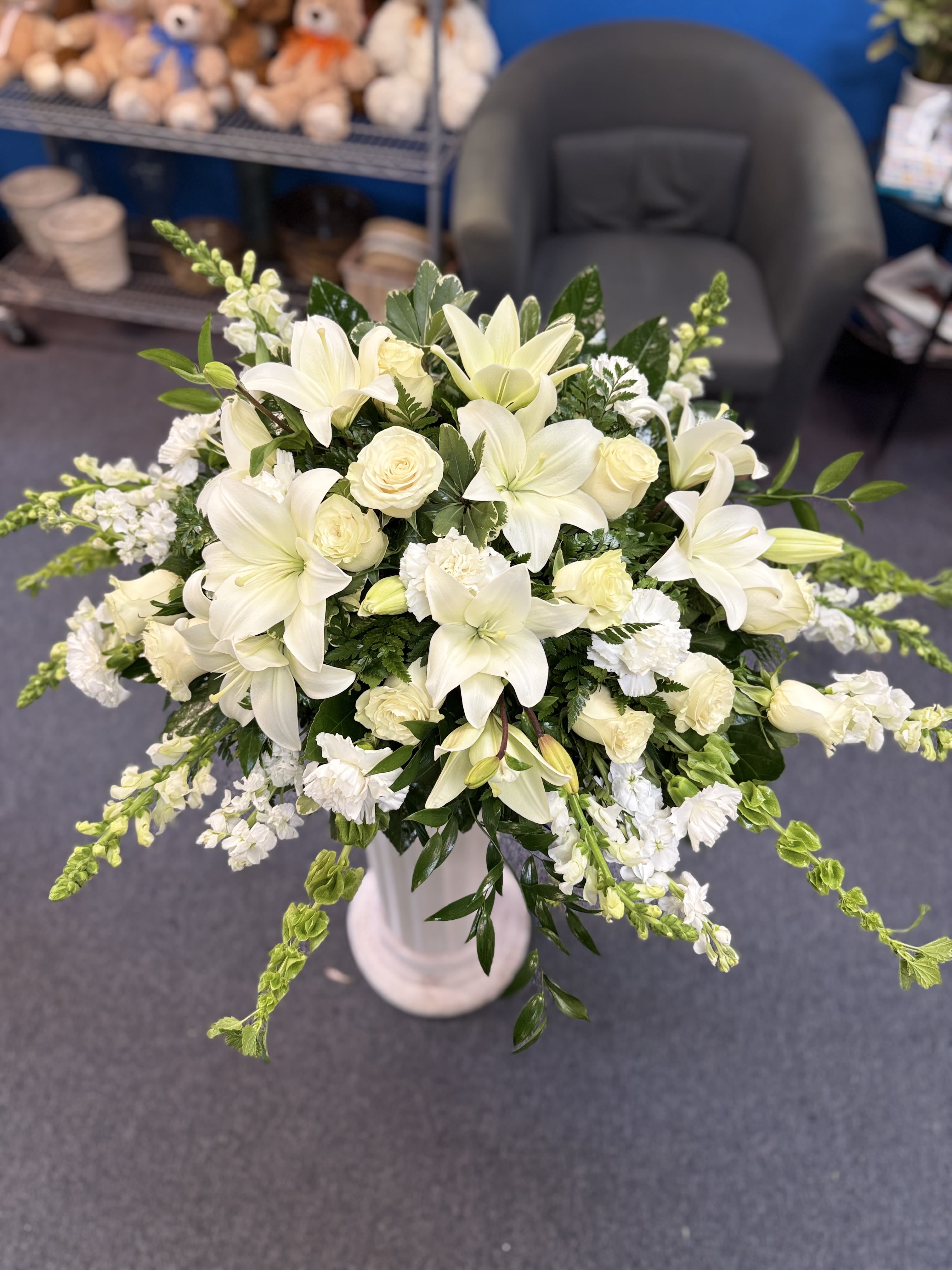 White lilies and roses arranged in a tall vase