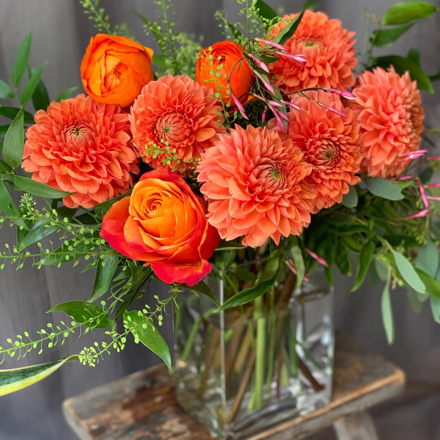 Mimosa - Roses and Dahlias with seasonal berries in clear vase.