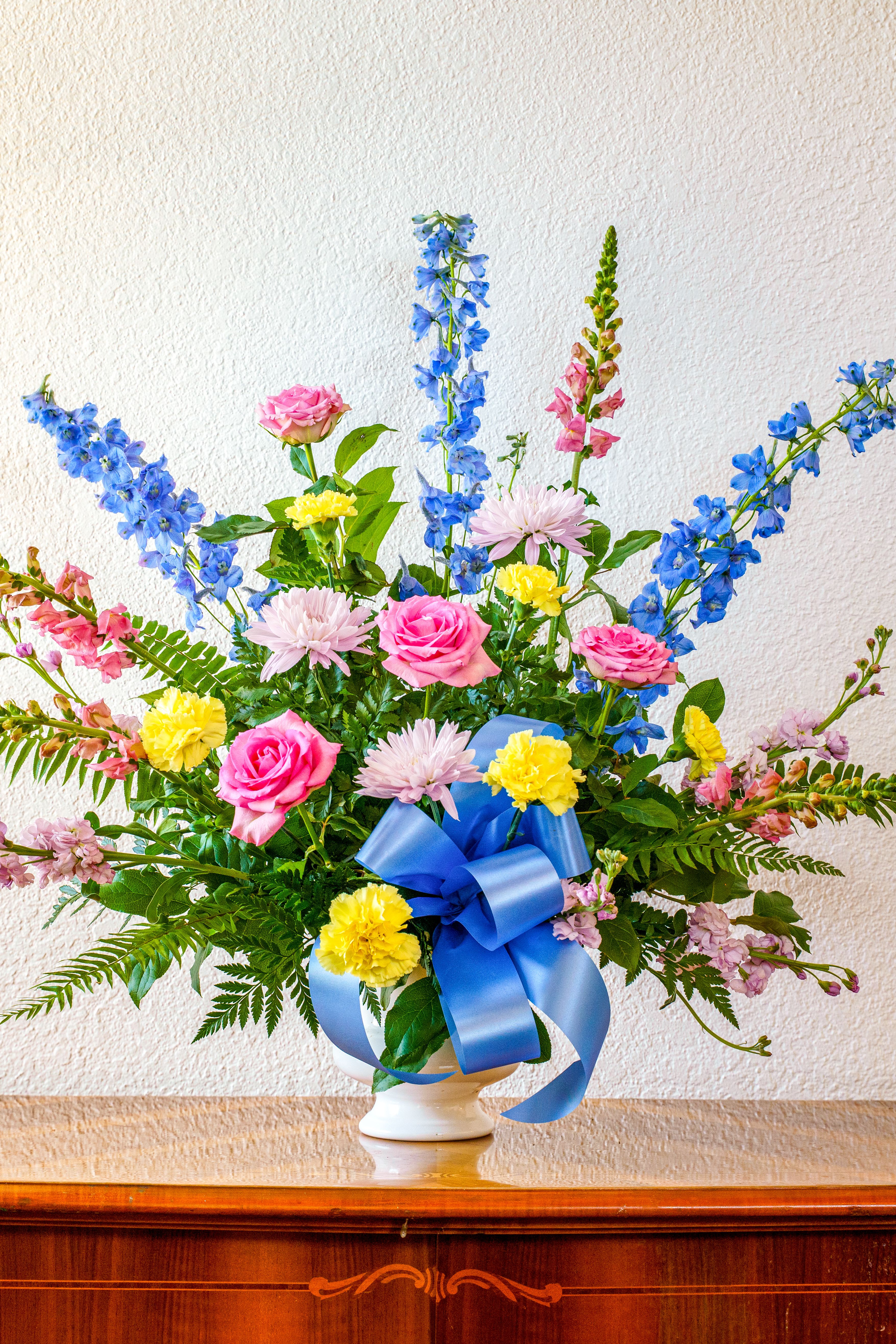 Garden Glory Tribute - Send the comforting feeling of an afternoon stroll through the garden. This tribute is a warm, loving way to honor their memory.  This piece is available for the addition of script to the ribbon.