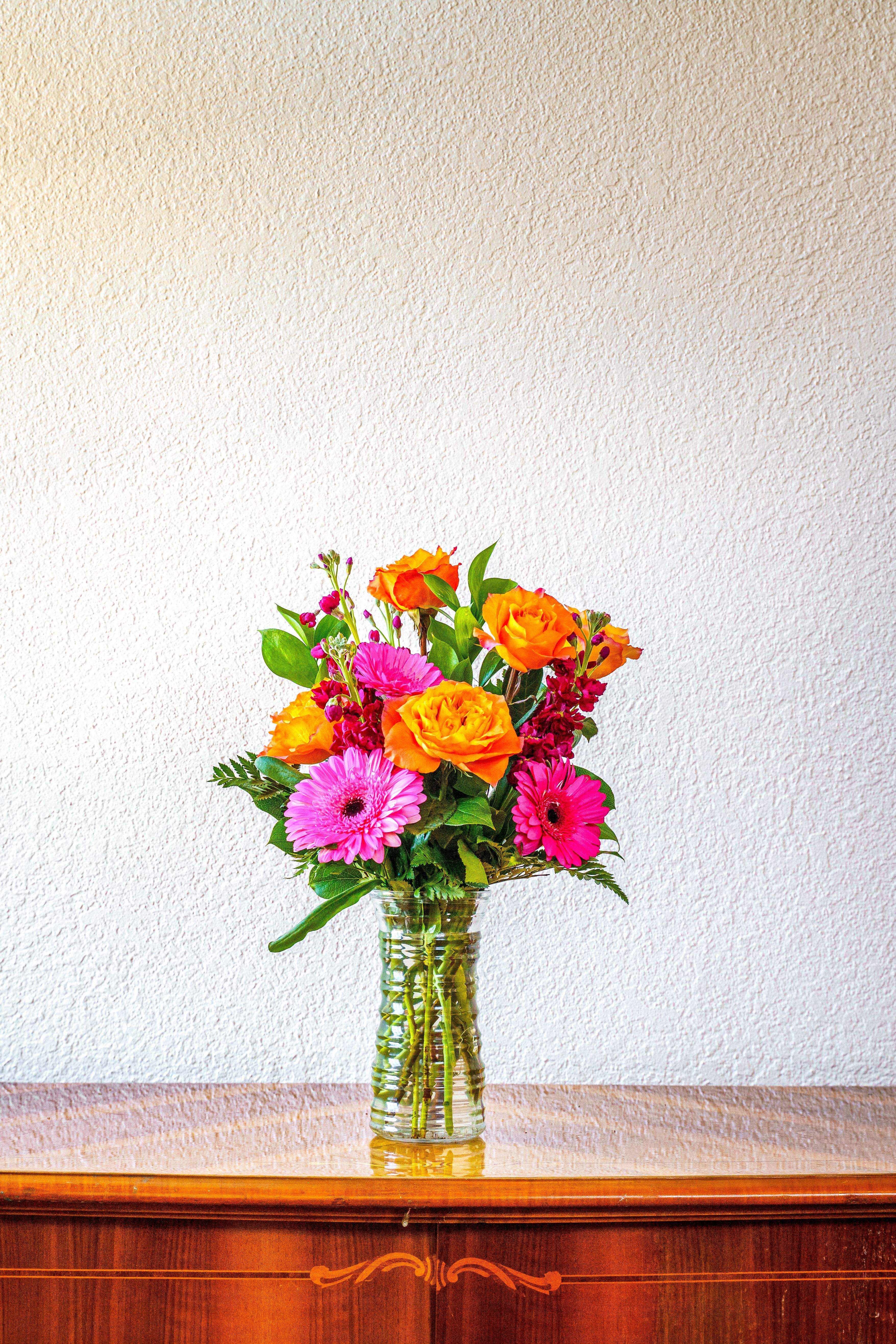 She's Electric - Send them flowers that are as vibrant as they are! These bright orange roses and hot pink daisies and stock are such a killer combo that can't be beat!