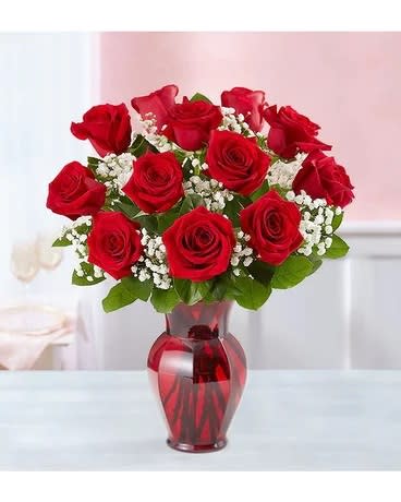 Red roses arranged in a red glass vase