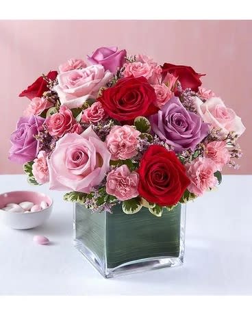 Pink and red rose arrangement in a square glass vase