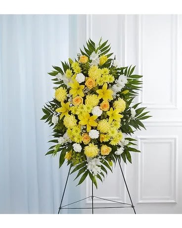 Standing floral spray with yellow and white flowers on an easel