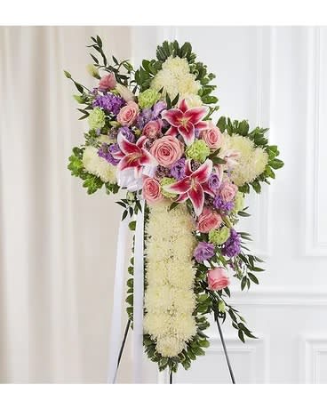Standing floral cross with pink roses and lilies on an easel