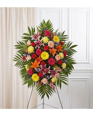 Standing floral spray with mixed bright flowers on an easel