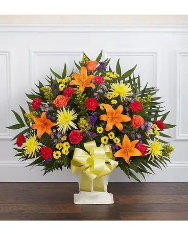 Standing floral spray with orange lilies and mixed bright blooms