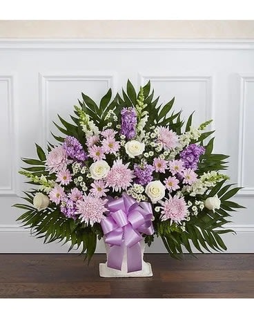 Lavender and white floral spray with a purple ribbon on a stand