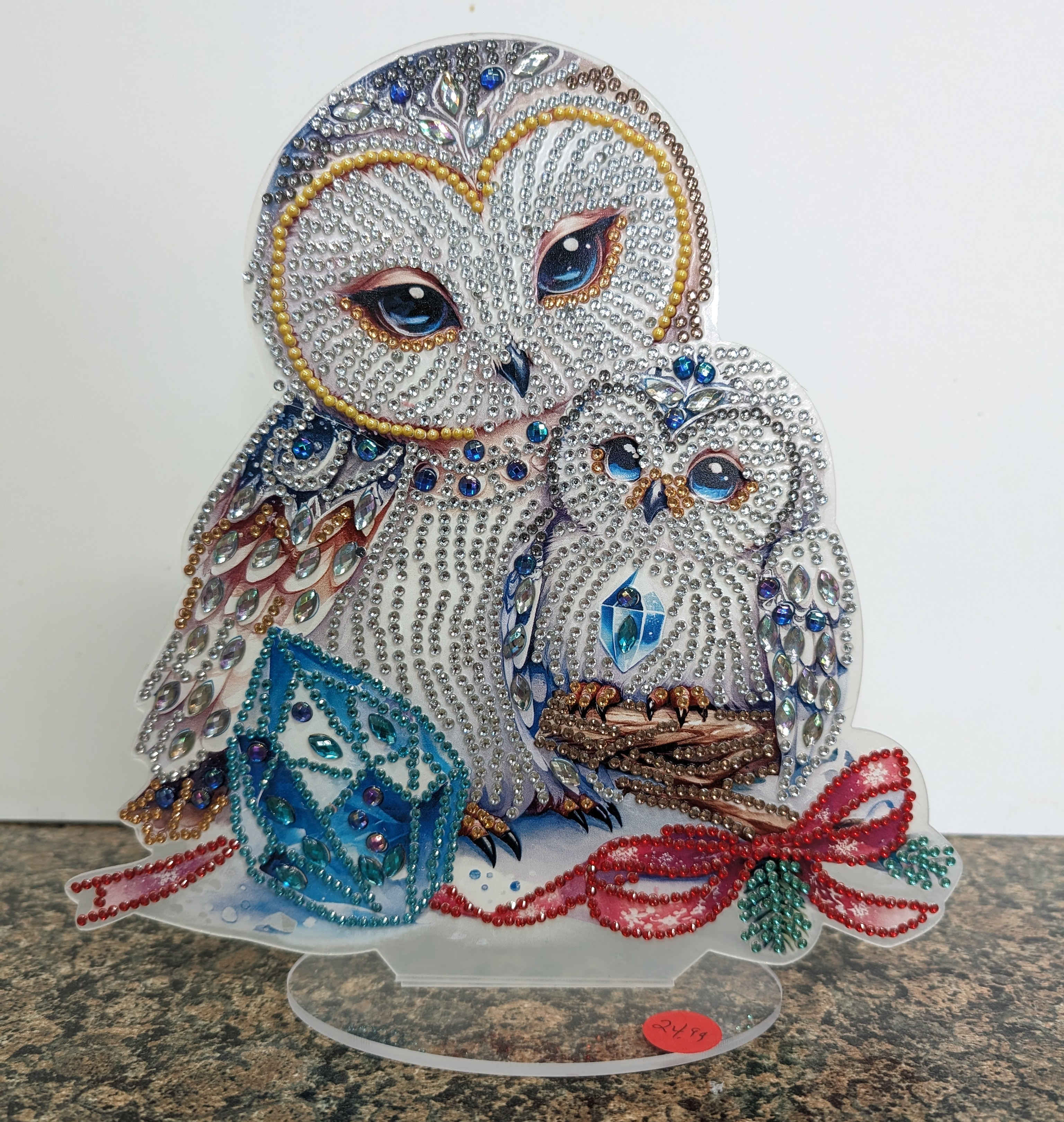 Jeweled owl and owlet figurine with blue gem cube and red beaded bow on a clear stand