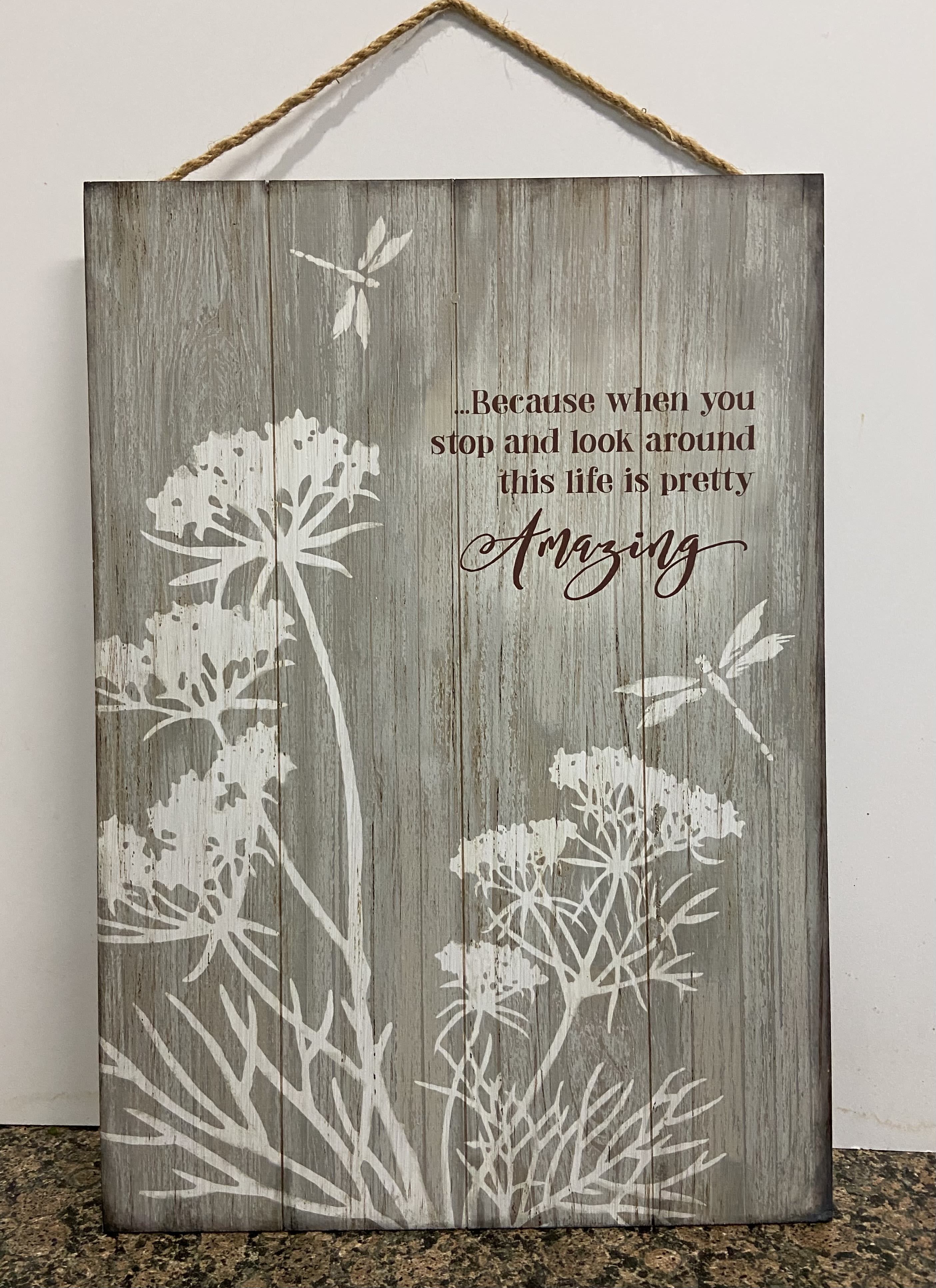 Rustic wood wall sign with white floral silhouettes, dragonflies, and an inspirational quote.