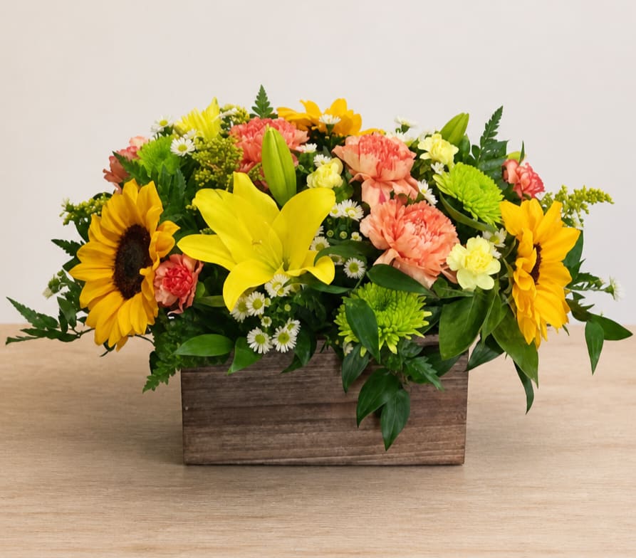 Mixed bouquet in a wooden box with sunflowers, lilies, and carnations