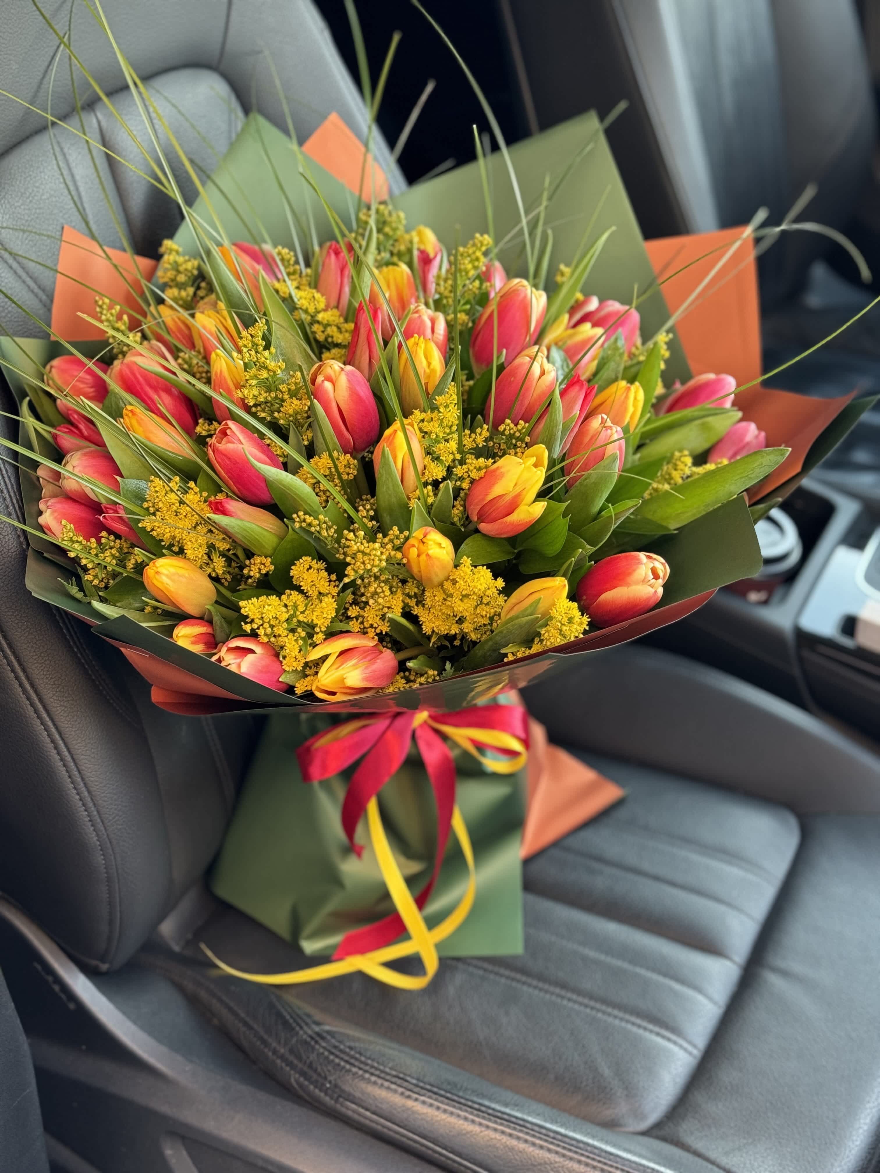 Bouquet of pink and yellow tulips with yellow filler flowers