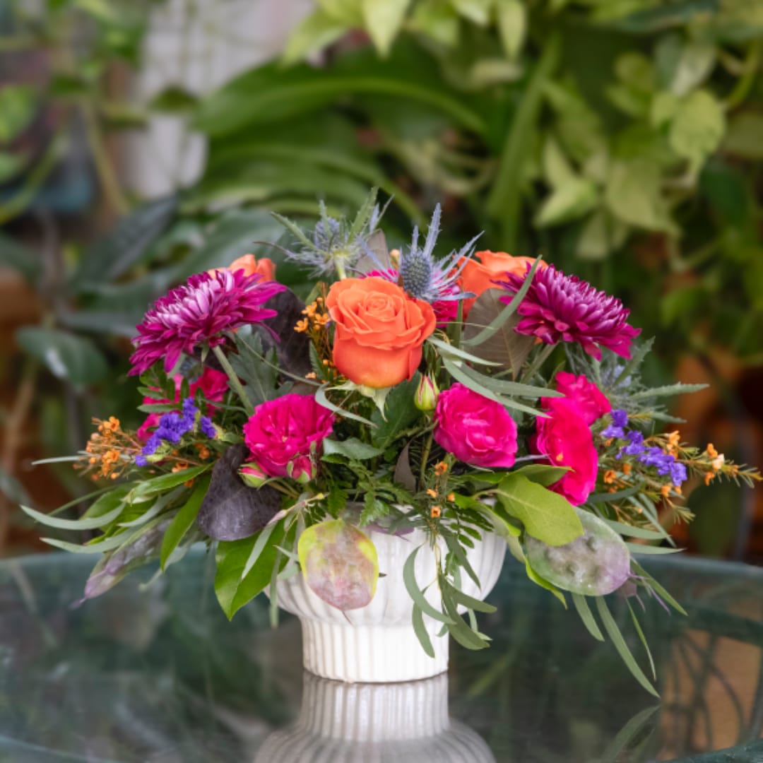 Bright mixed flower arrangement in a white vase