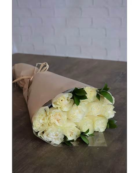 Bouquet of cream-colored roses wrapped in tan paper
