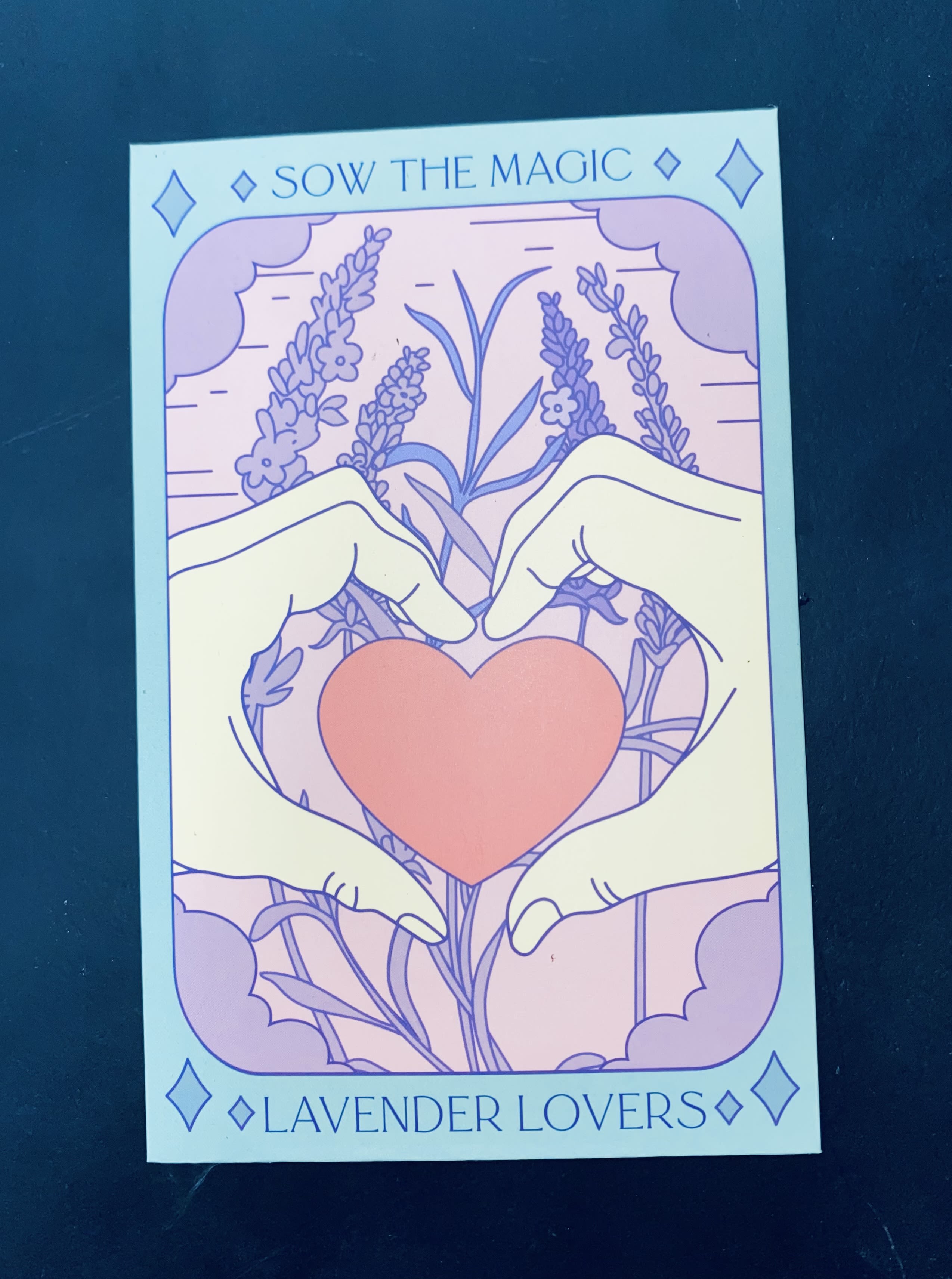 Illustrated hands forming a heart around a pink heart with lavender flowers