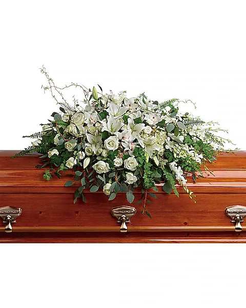 White floral spray on a wooden casket
