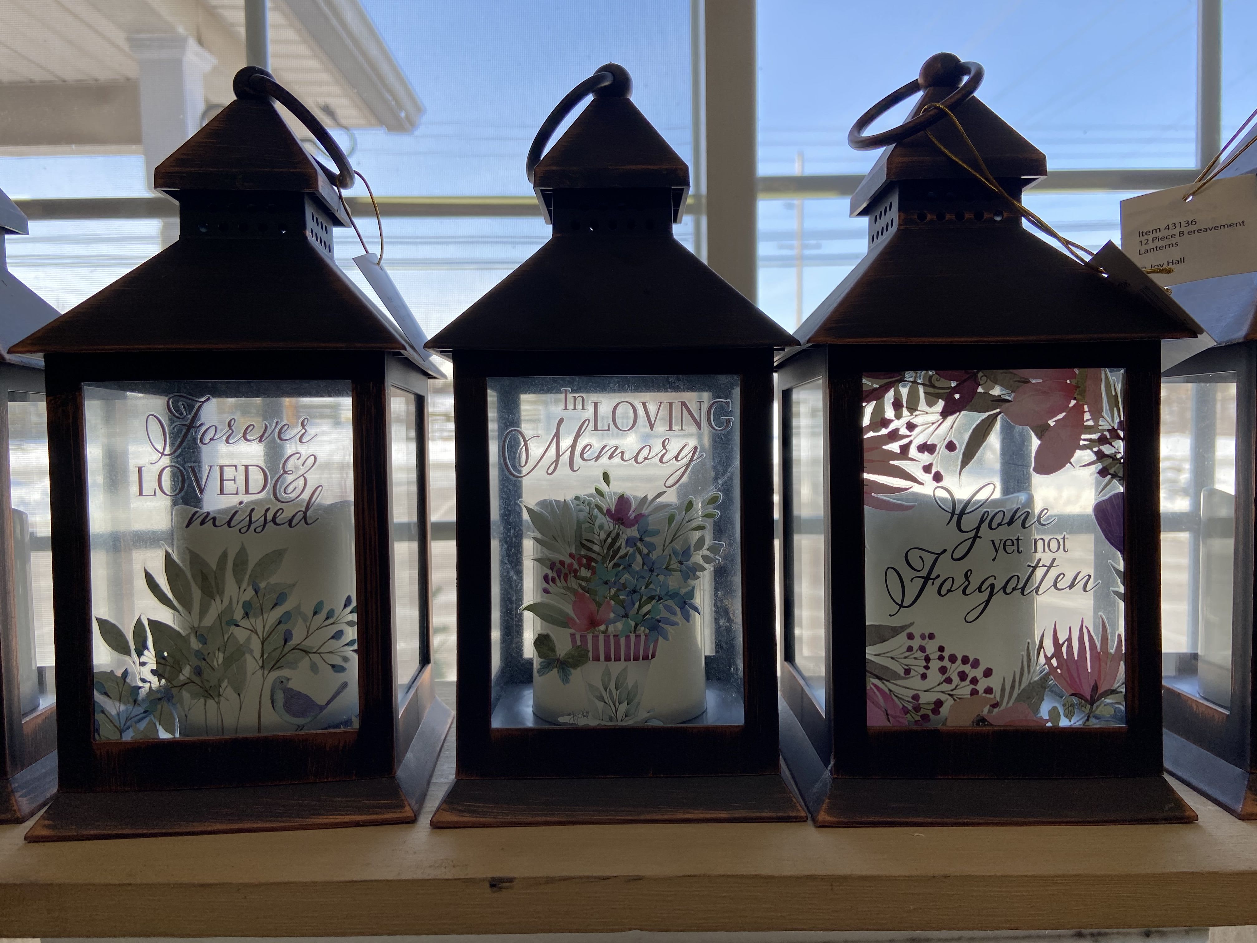 Three memorial lanterns with sentimental text and floral designs