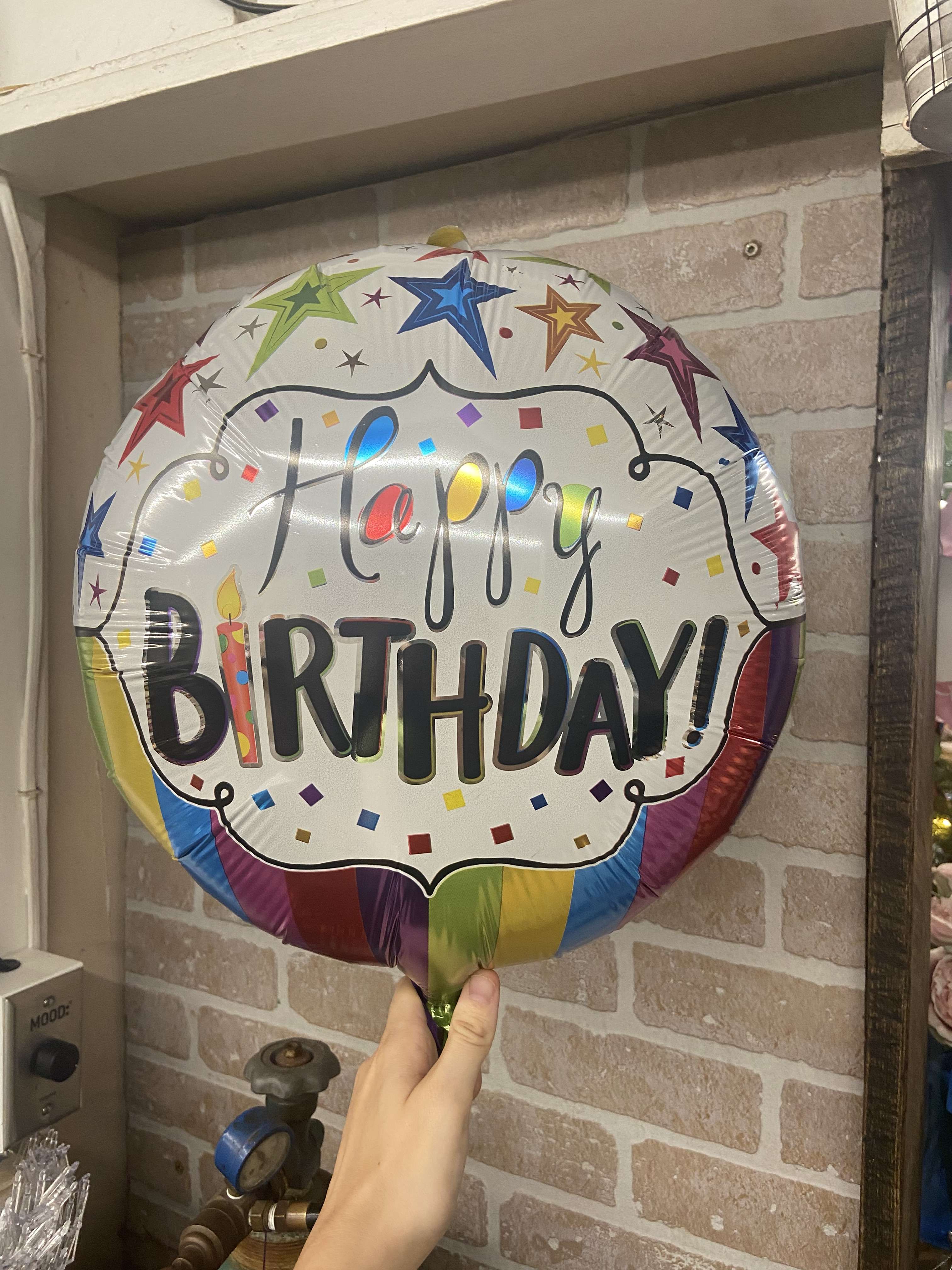 Round birthday balloon with colorful stars and confetti design