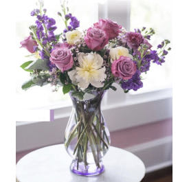 Purple and white bouquet in a clear glass vase