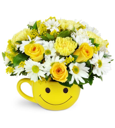 Yellow smiley-face mug filled with yellow roses and white daisies
