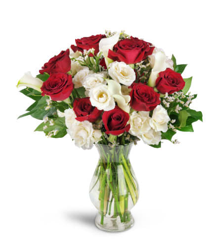 Red and white roses with calla lilies in a glass vase