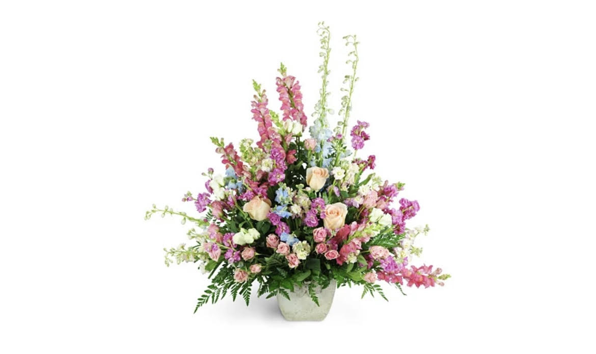 Tall mixed flower arrangement in a white vase
