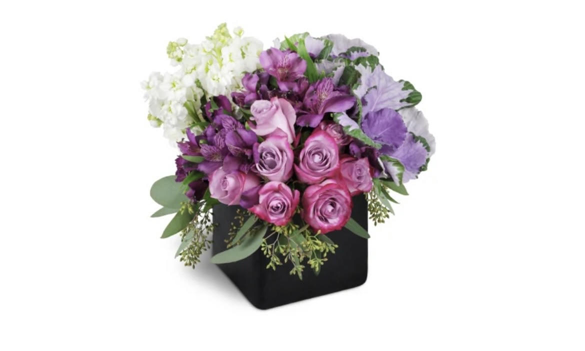 Pink and purple roses arranged in a black square vase
