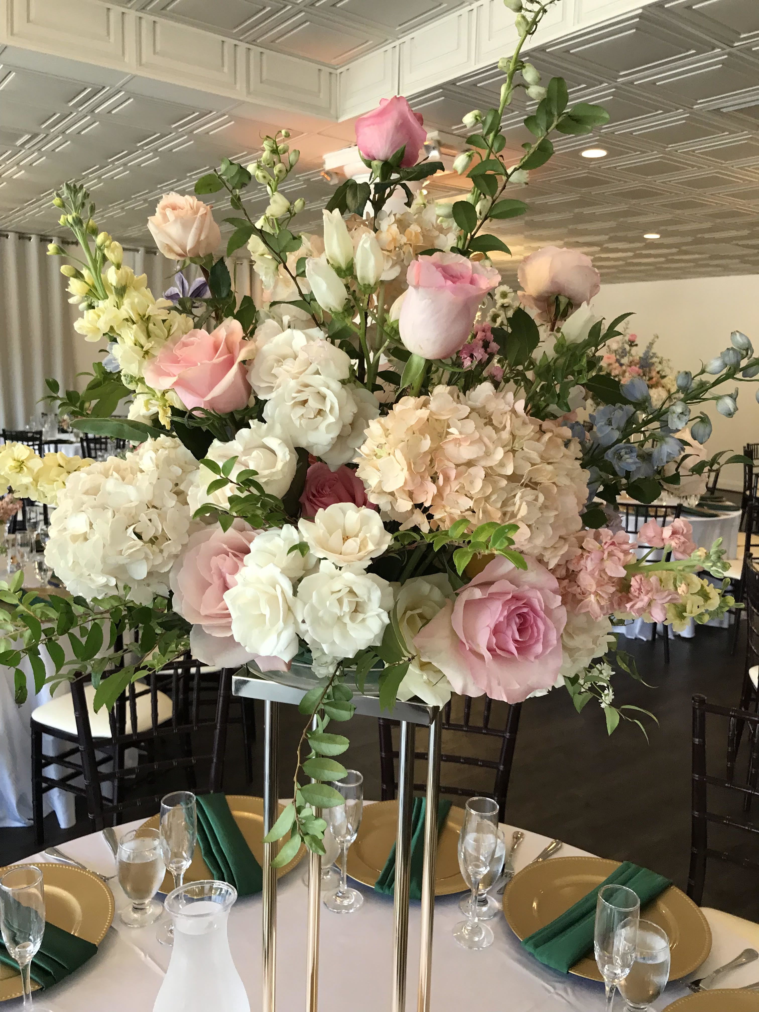 Tall pastel floral centerpiece with pink and white roses and hydrangeas