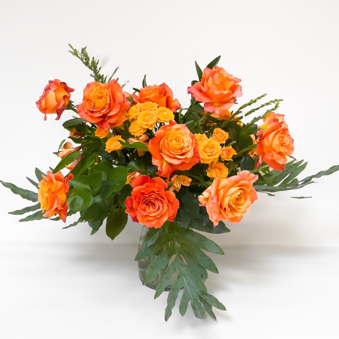 Orange roses arranged in a clear glass vase