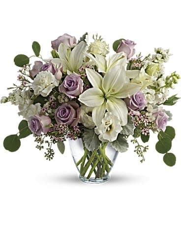 Lavender roses and white lilies in a clear glass vase