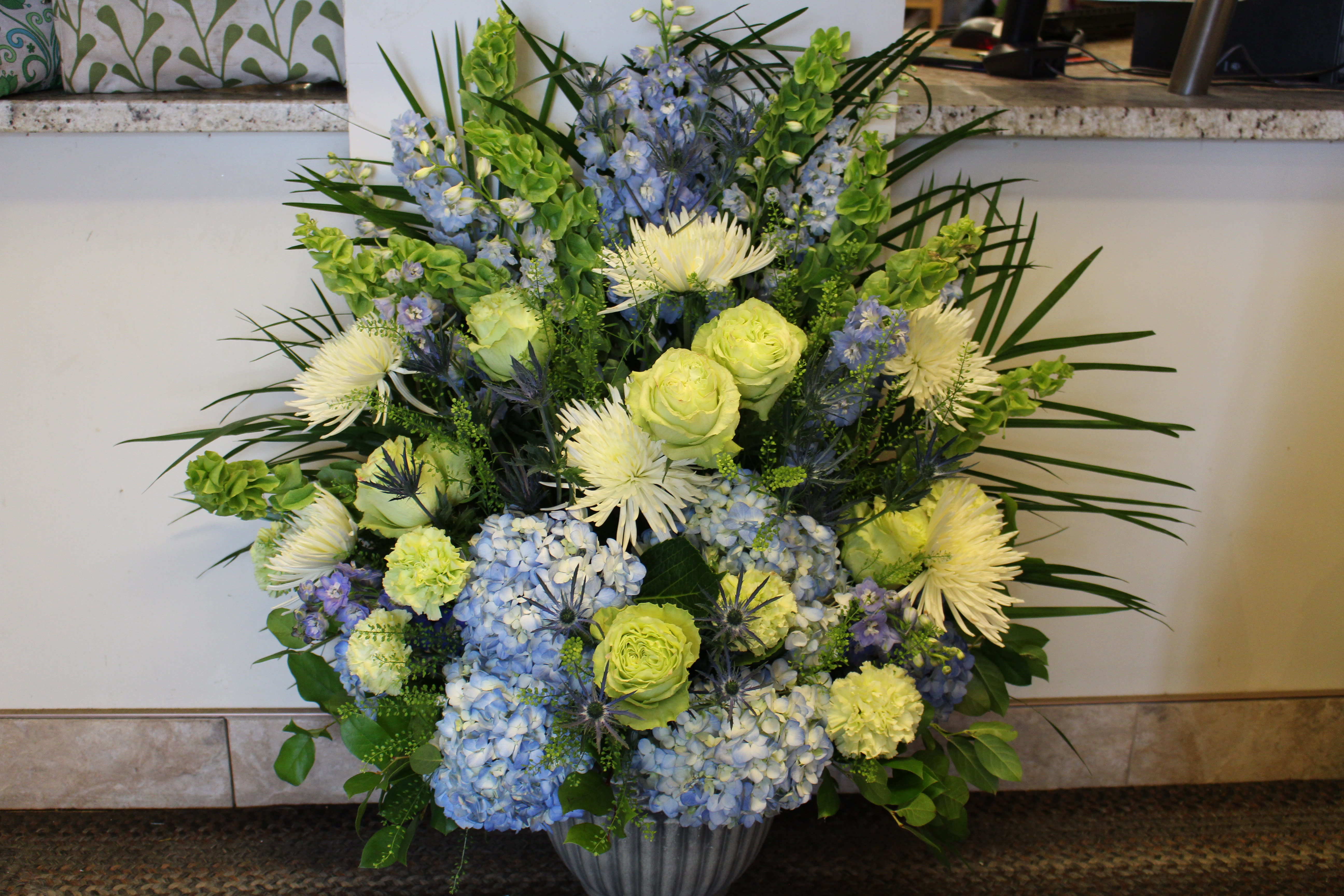 Blue and yellow floral arrangement in a vase