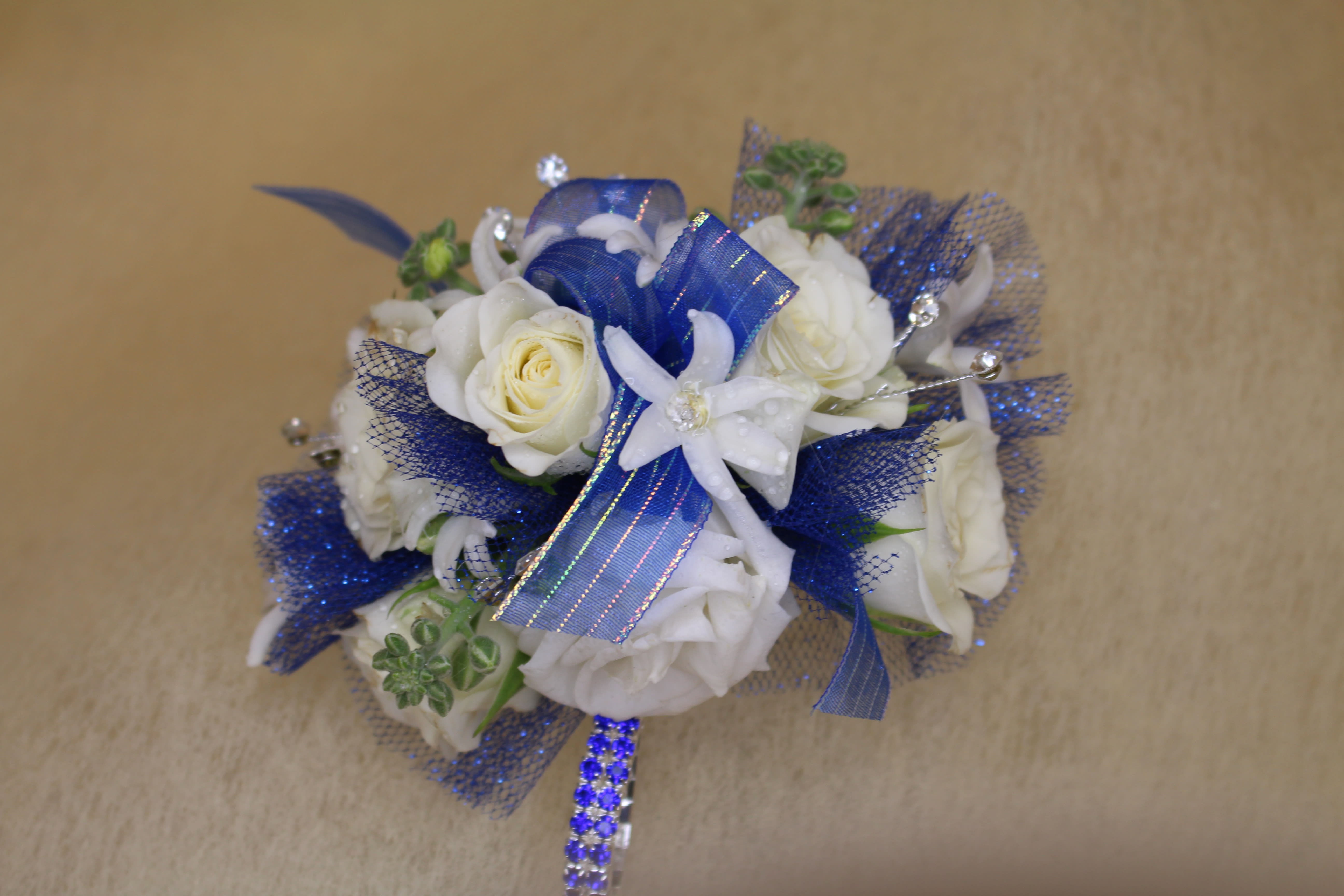 White roses with blue ribbon and mesh accents