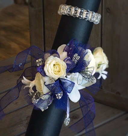 White roses and lilies with blue ribbon on a black handle