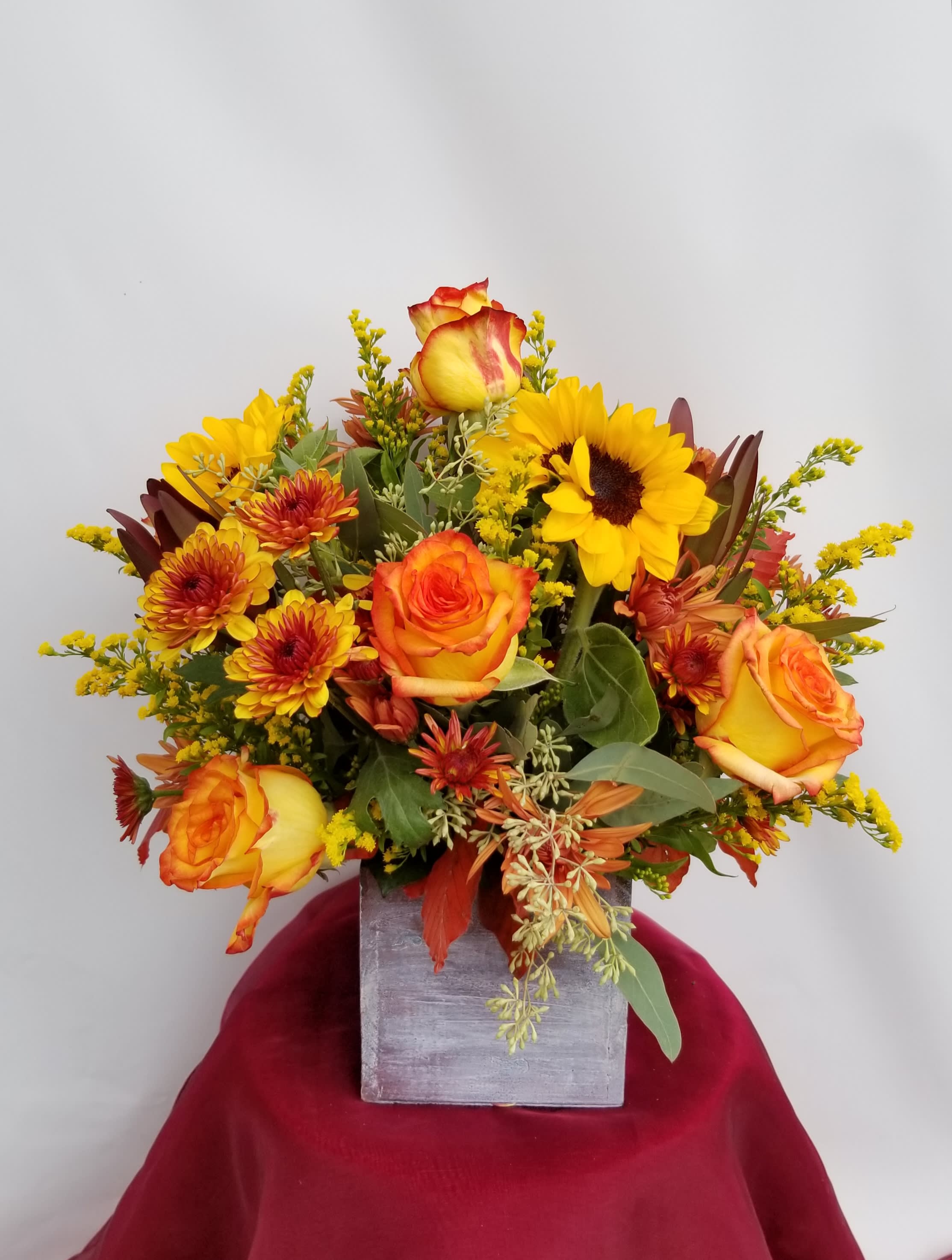 Orange and yellow bouquet in a square gray vase