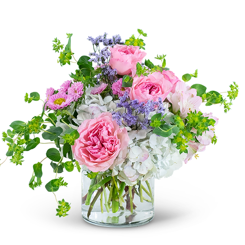 Pink roses and mixed flowers in a clear glass vase