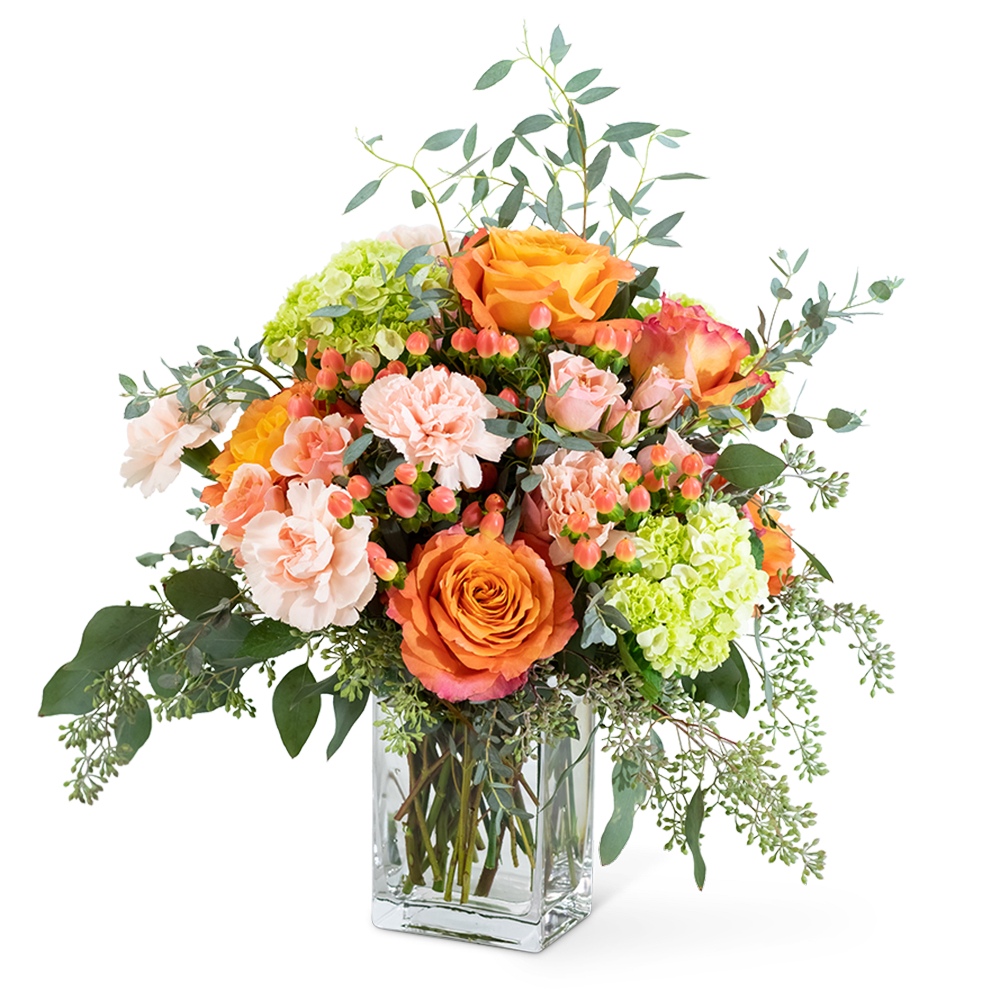 Orange and peach roses with pink carnations in a glass vase