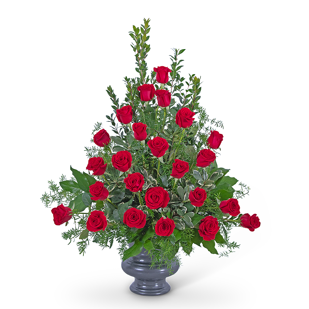 Red roses arranged in a gray vase with greenery