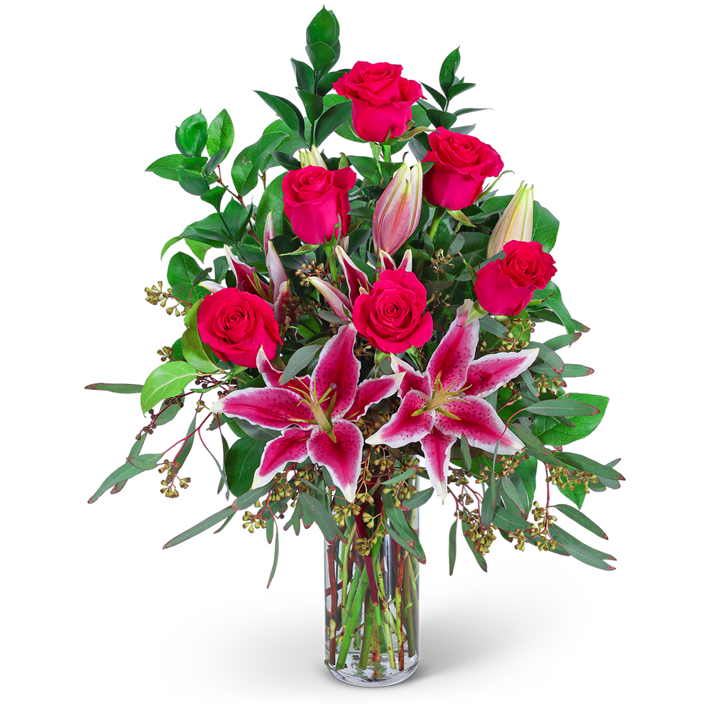 Pink roses and lilies arranged in a clear glass vase