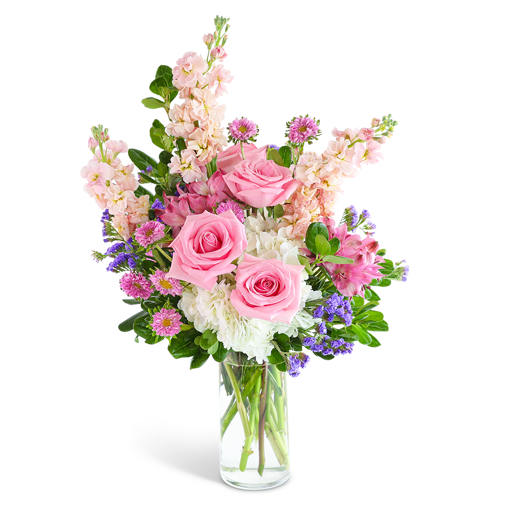 Pink roses and mixed flowers arranged in a clear glass vase