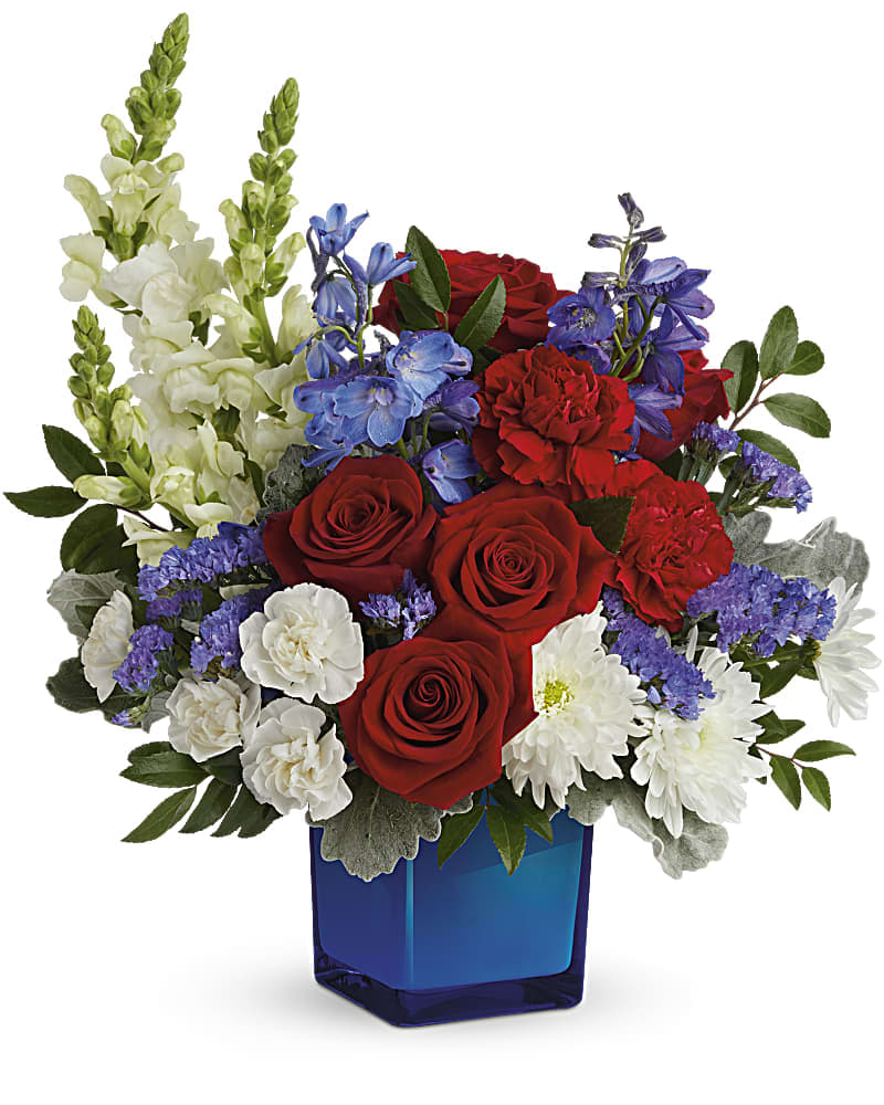 Red roses, white snapdragons, and purple flowers in a blue glass vase