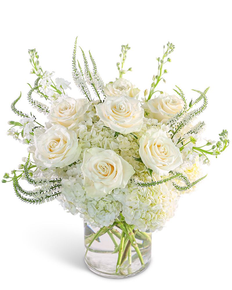 White roses and hydrangeas in a clear glass vase