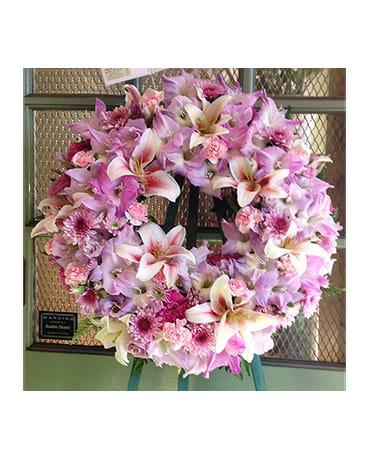 Pink and white floral wreath on a stand